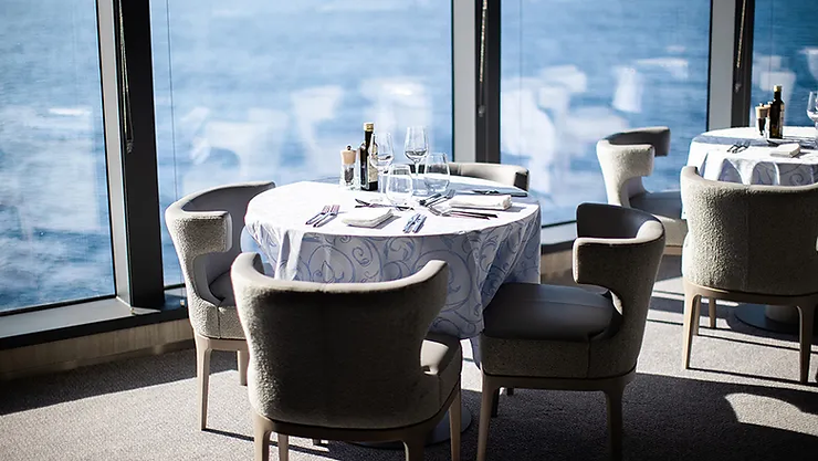 Le Commandant Charcot offers buffet-style meals and themed dinners with global dishes like Thai curries, French classics, and salads that guests can enjoy while gazing out at the icy expanse of the Arctic.