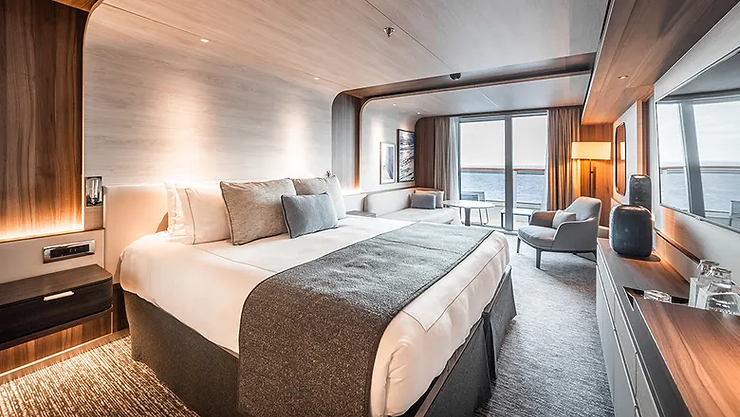 Le Commandant Charcot’s Deluxe Suite features refined interiors, spacious living areas, and private balconies that offer panoramic polar views.